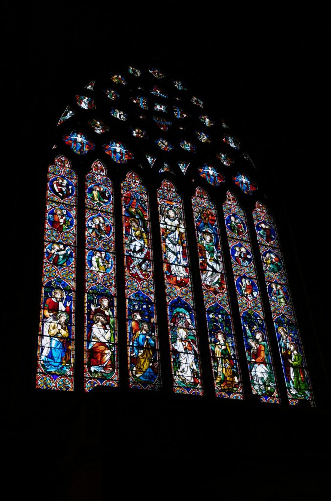 a colorful stained glass window against black macourt media from unsplash