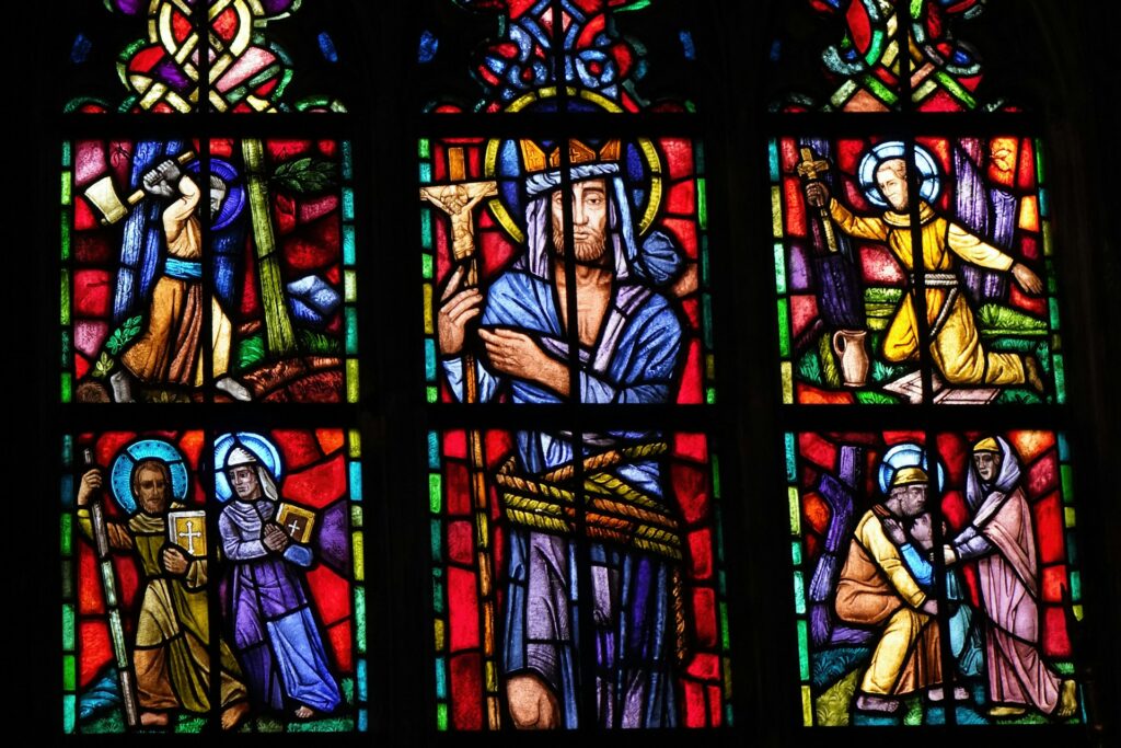 a stained glass window with a man holding a cross wroclaw church poland