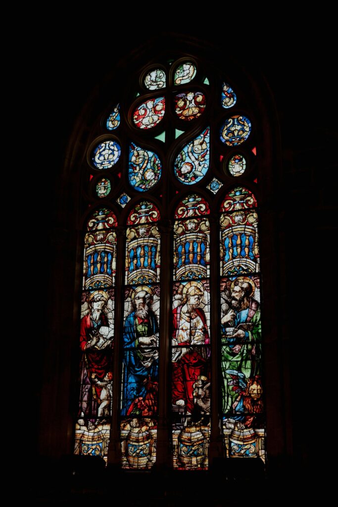 ornate stained glass window with religious figures cathedral de sevilla, espana vik molina 83hog1vljmu unsplash