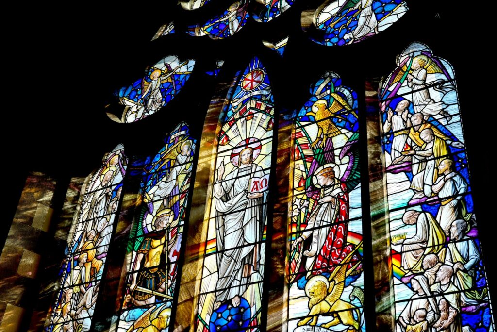 stained glass windows illuminate the church interior st.mary's church, church hill, swanage, uk hannah fleming hlll from unsplash