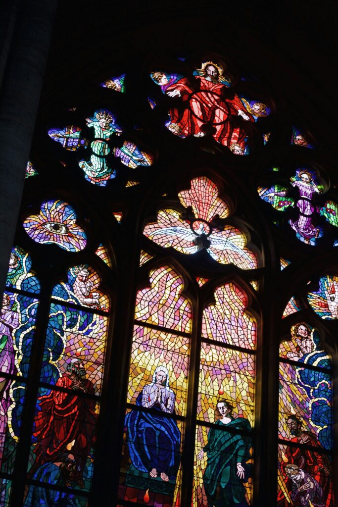 a large stained glass window in a church lina from unsplash