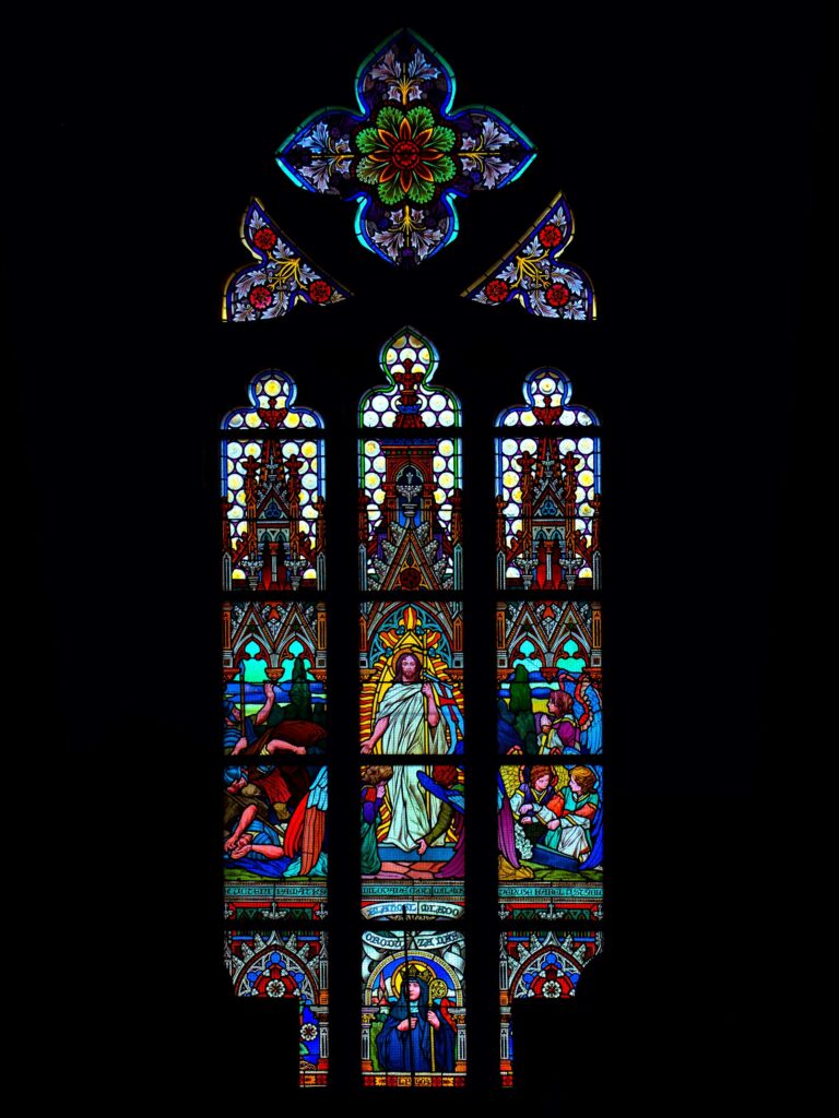 a large stained glass window in a dark room lazarevmaru from unsplash