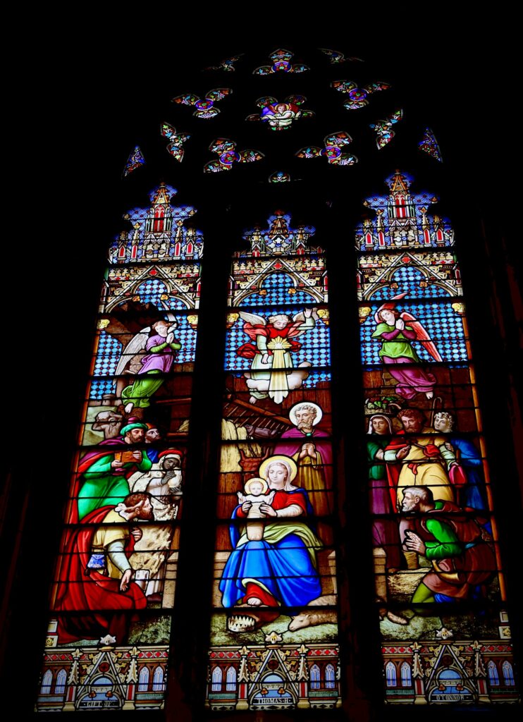 a very large stained glass window in a building angelo moleele from unsplash