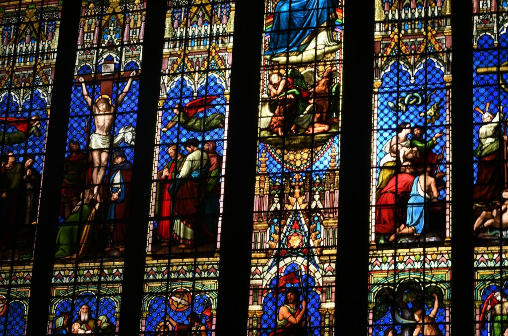 a very large stained glass window in a church building simon haslett from unsplash
