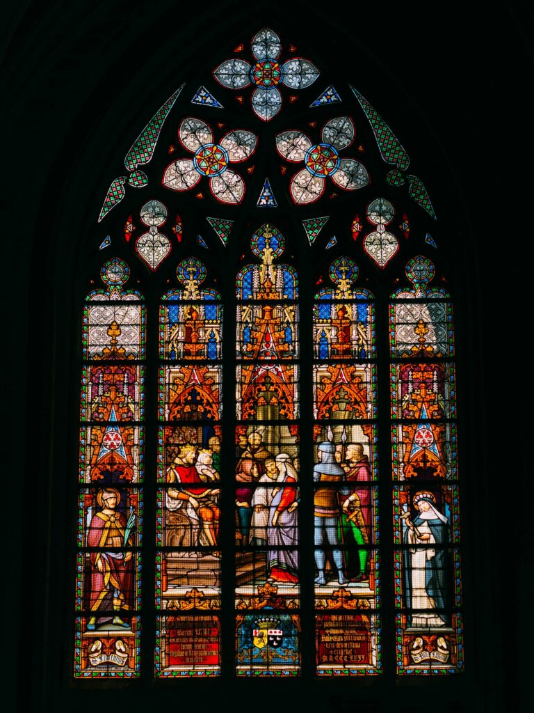 blue red and yellow floral glass window brecht denil from unsplash