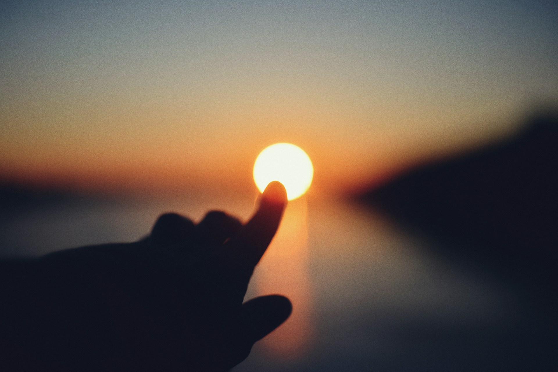 finger pointing at sun