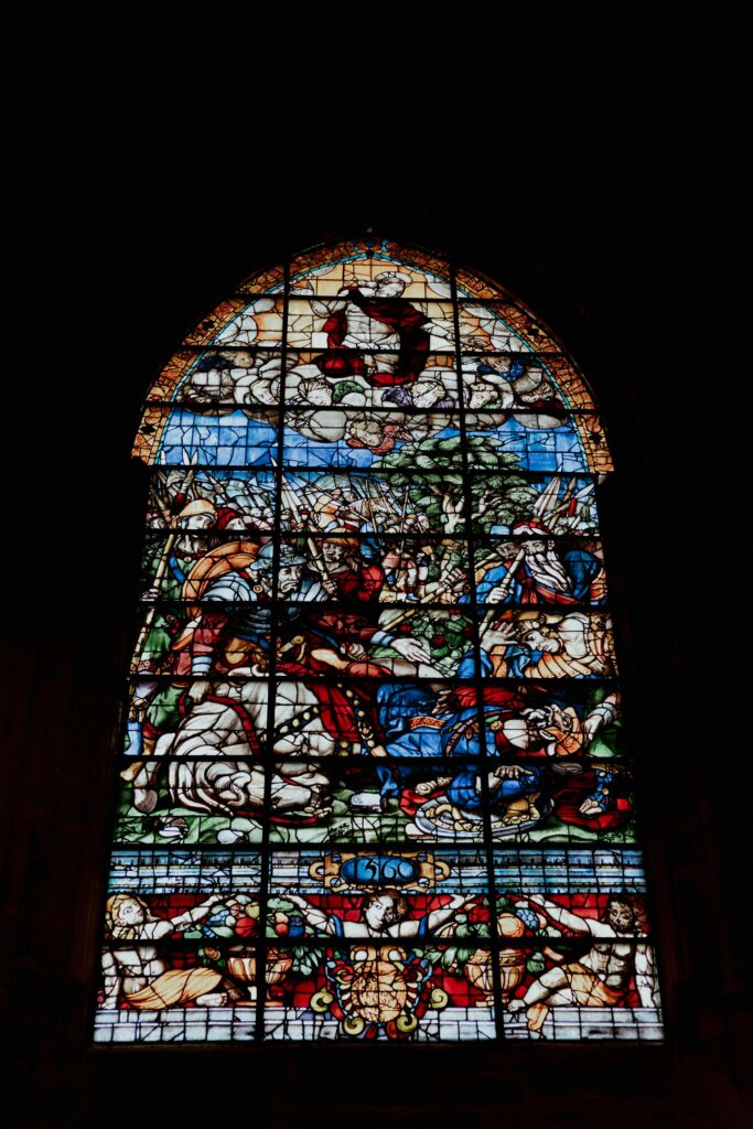 stained glass window with biblical scenes cathedral de sevilla, espana vik molina from unsplash